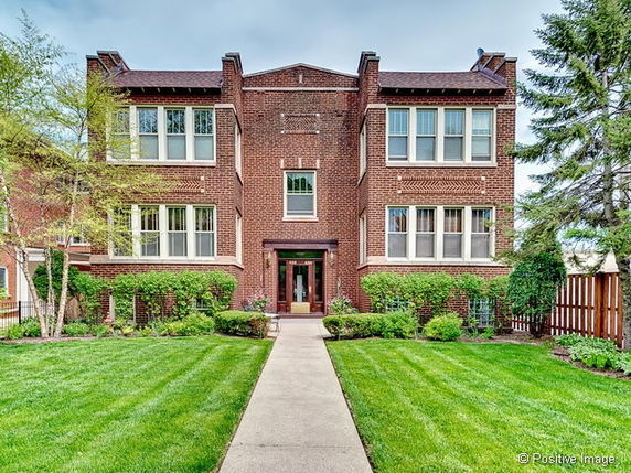 Front view of a two-story brick building with multiple windows.