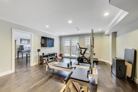 Indoor gym area with exercise equipment and large windows.