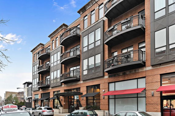 Front view of a multi-story residential building with balconies.