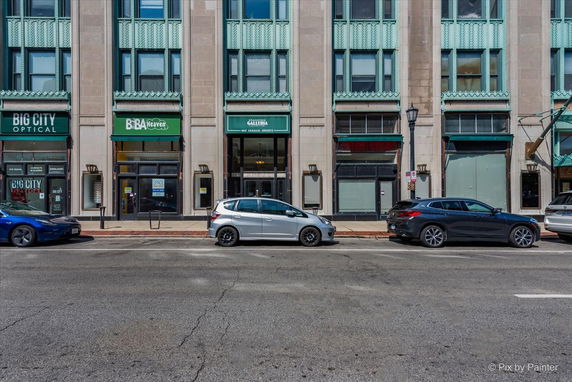 Front view of a multi-story building with retail storefronts at street level.