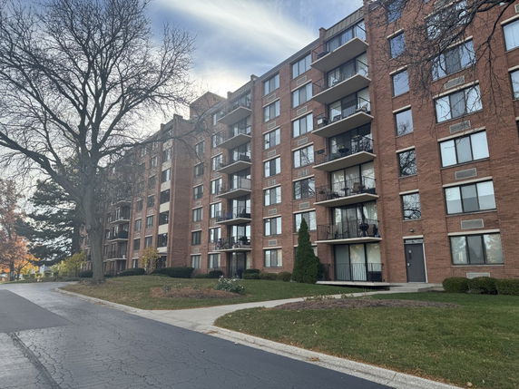 Front view of a multi-story apartment building with balconies.