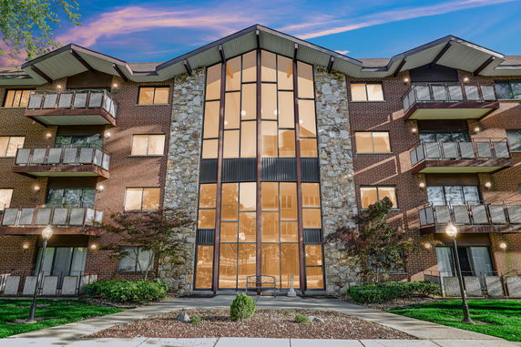 Front view of a multi-story building with balconies and large central windows.