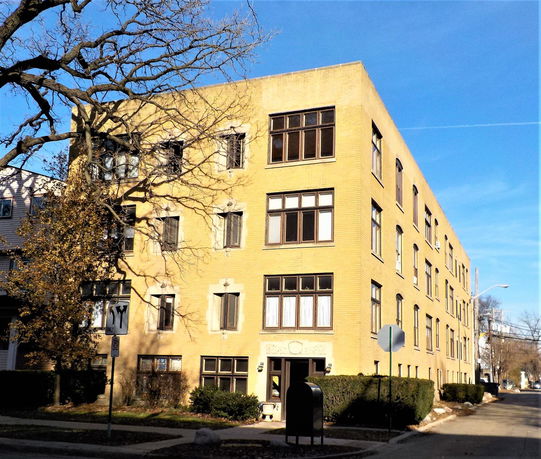 Front view of a four-story brick apartment building.