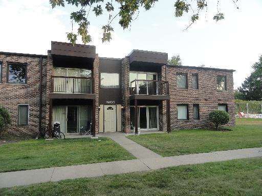 Front view of a two-story apartment building with balconies and a central entrance.