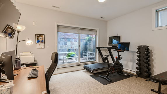 Home gym with exercise bike, treadmill, and weights.