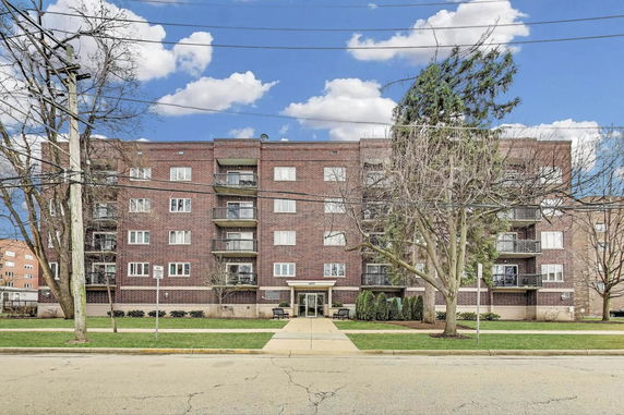 Front view of a multi-story apartment building with balconies.