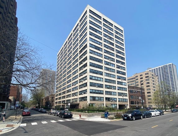 Front view of a multi-story apartment building on a city street corner.