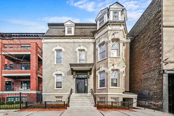Front view of a multi-story house with ornate architectural details.