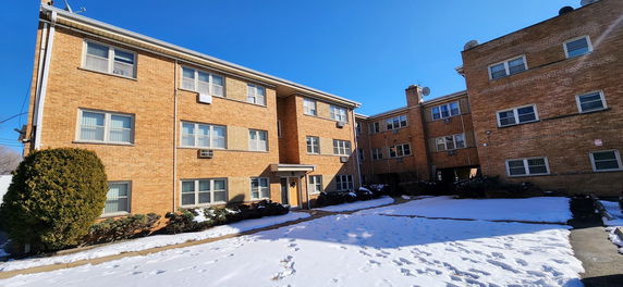 Front view of a multi-story brick apartment building.