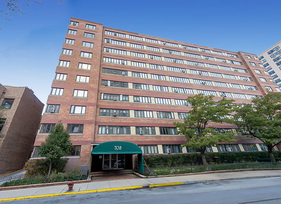 Front view of a multi-story apartment building with brick facade.