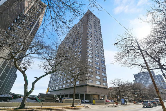 Front view of a tall apartment building with multiple windows.