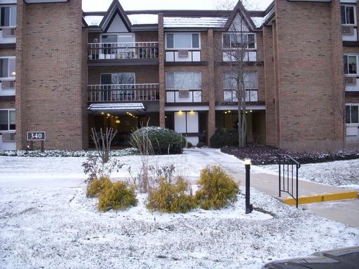 Front view of a multi-story brick building with balconies.