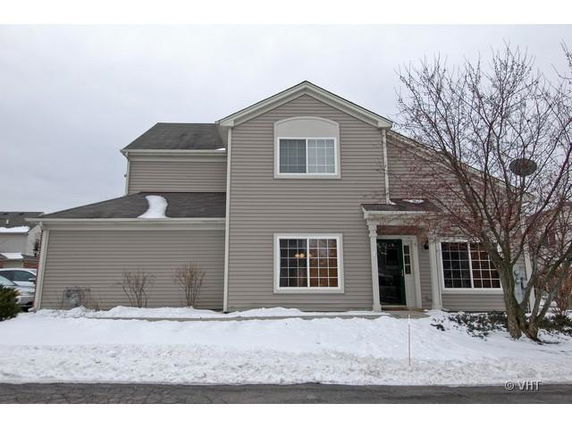 Front view of a two-story house with a snow-covered roof.