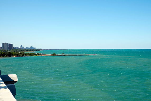 Wide view of the ocean with distant buildings on the coastline.