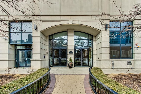 Front view of a building entrance with glass doors and large windows.