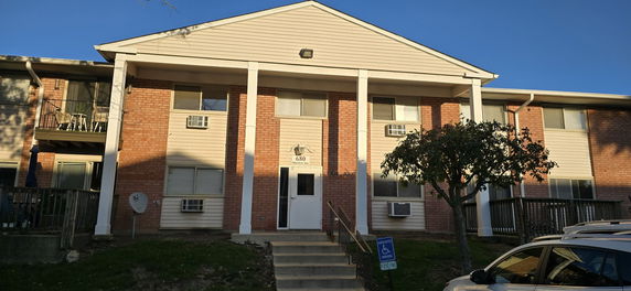 Front view of a two-story apartment building with brick and siding exterior.