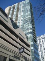 View of a tall modern high-rise building with glass windows and balconies.