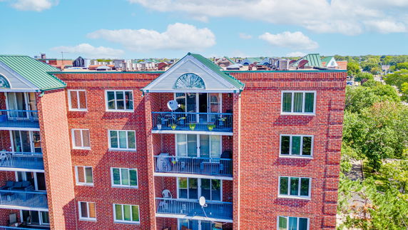 Front view of a brick apartment building with balconies.