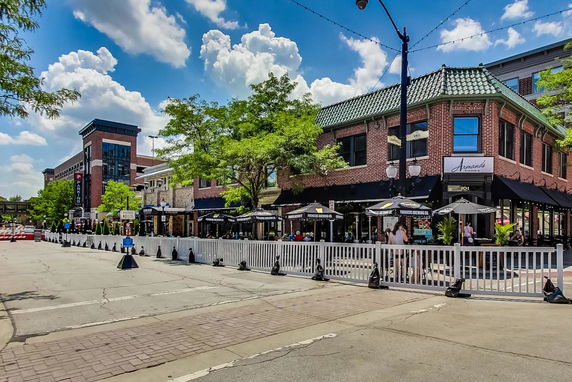 Front view of a brick building with outdoor seating.