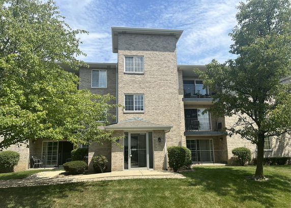 Front view of a multi-story residential building with balconies.