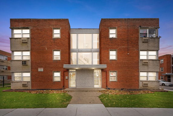 Front view of a multi-story brick apartment building.