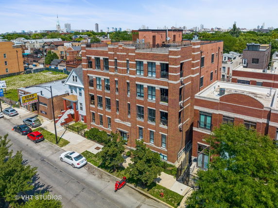 Front view of a multi-story brick residential building with large windows.