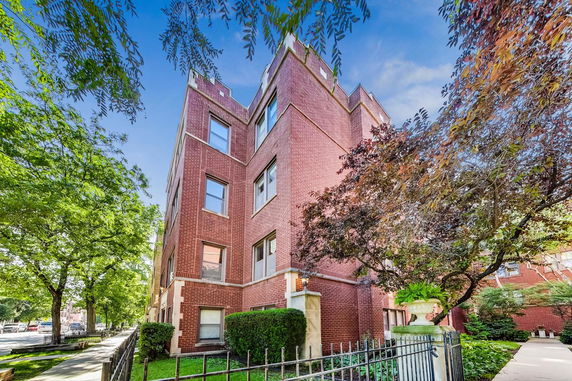Front view of a multi-story brick apartment building.