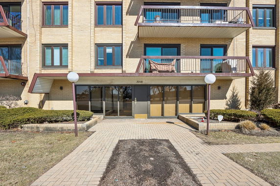 Front view of a building with multiple balconies and glass entrance.