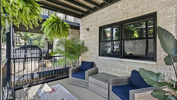 View from a balcony area with seating and plants, looking out onto surrounding areas.