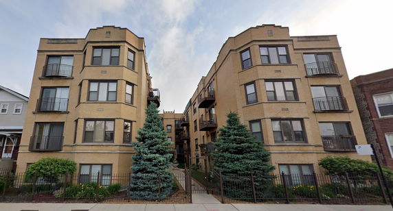 Front view of a multi-story building with symmetrical architecture and balconies.