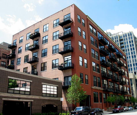 Front view of a multi-story apartment building with balconies.