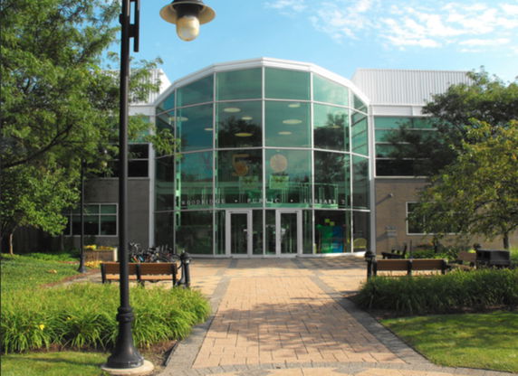 Front view of a library building with large glass windows and a modern design.