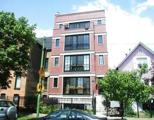 Front view of a multi-story brick building with balconies.