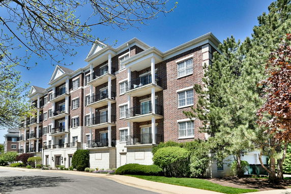 Front view of a multi-story residential building with balconies and brick exterior.