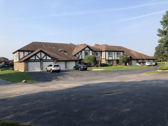 Front view of a multi-story residential building with multiple garages.