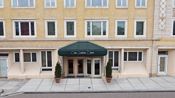 Front view of a multi-story building with a green entrance canopy.