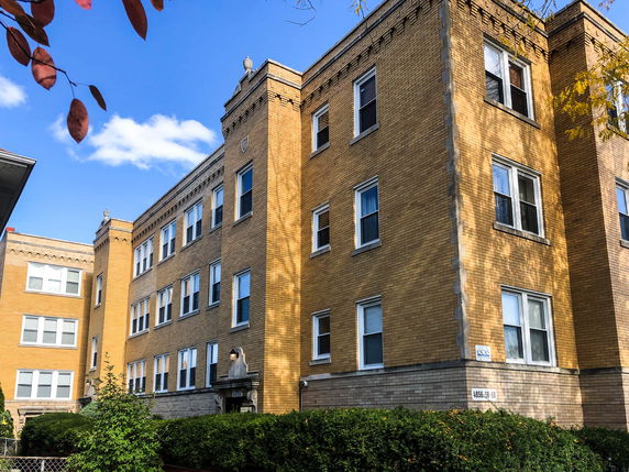 Front view of a multi-story brick building with numerous windows.