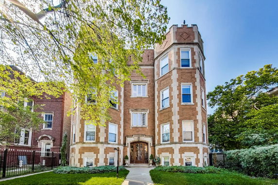 Front view of a multi-story brick building with decorative stone accents.
