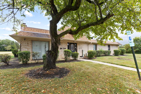 Front view of a single-story brick house with a pitched roof.