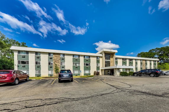 Front view of a three-story building with parking spaces.