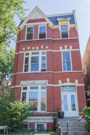 Front view of a three-story brick building with decorative architectural details.