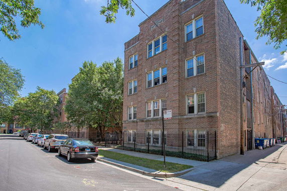 Front view of a multi-story brick building on a residential street.