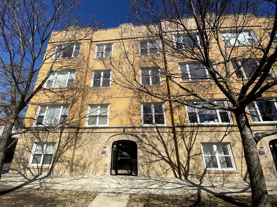 Front view of a multi-story apartment building with brick facade.