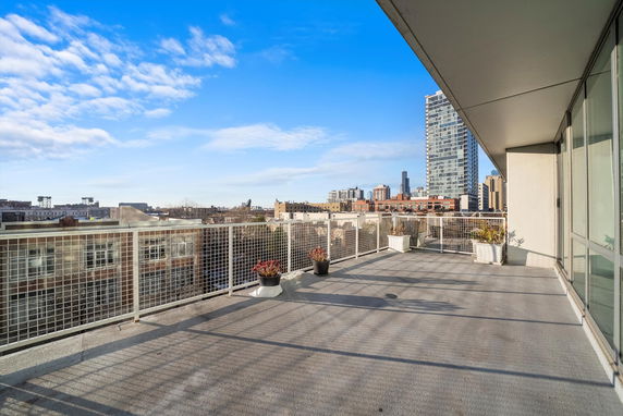 Panoramic view from a building's balcony showing city skyline.