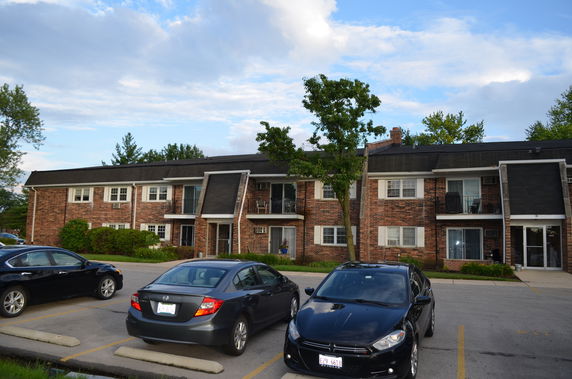 Front view of a two-story brick apartment building with balconies.
