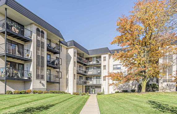 Front view of a multi-story apartment building with balconies.