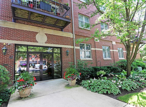 Front view of a brick building with large glass doors and windows.