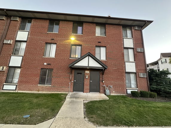 Front view of a multi-story brick building with multiple windows and a main entrance.