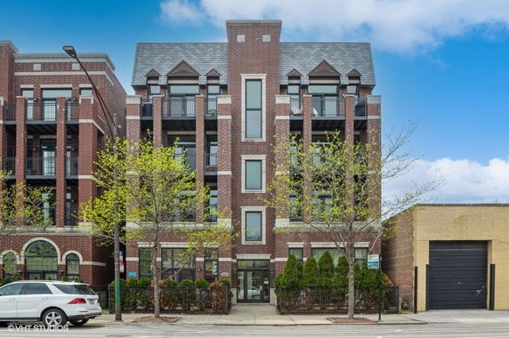 Front view of a multi-story brick building with balconies.