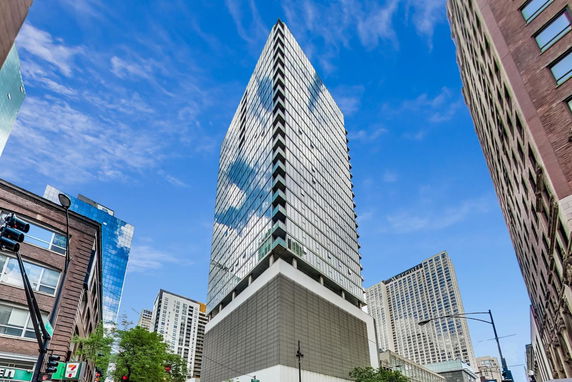 Front view of a modern high-rise building with glass windows and a unique architectural design.
